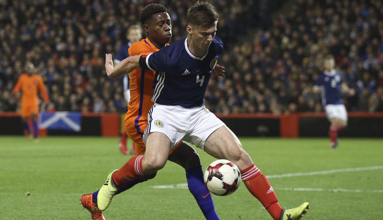 Pemain Skotlandia, Kieran Tierney (kanan) diadang pemain Belanda, Quincy Promes pada laga persahabatan di Pittodrie, Aberdeen, Skotlandia (9/11/2017). Belanda menang 1-0. (Andrew Milligan/PA via AP)