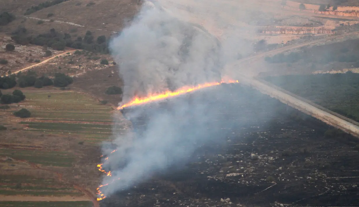 Api membakar lahan setelah serangan artileri berat Israel di desa perbatasan Maroun Al-Ras, Lebanon, Minggu (1/9/2019). Israel mengatakan telah membalas dengan artileri dan tembakan helikopter sebanyak sekitar 100 tembakan ke perbatasan di posisi-posisi Hizbullah. (AP Photo/Mohammed Zaatari)