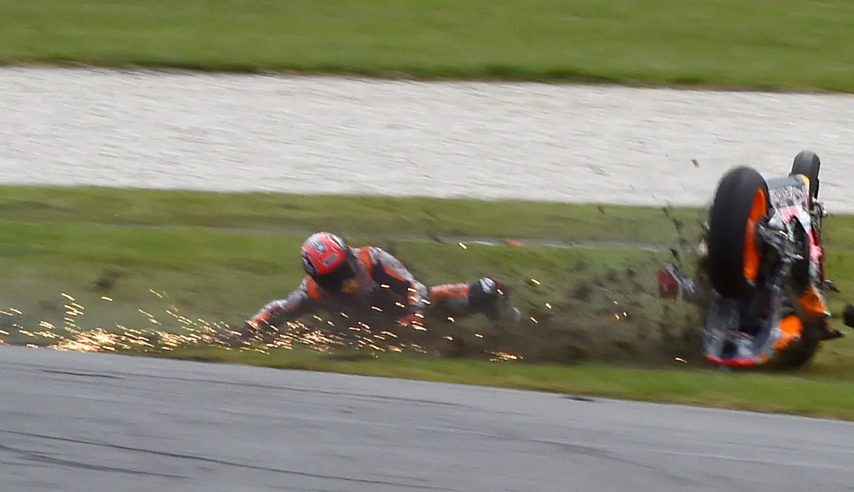 Saat pembalap Marc Marquez terjatuh saat balapan MotoGP Australia di Sirkuit Philip Island, Australia (21/10). Insiden tersebut menjadikan pembalap di belakangnya, Cal Cruthlow berada di tempat pertama. (AFP/Paul Crock) 
