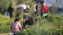Usai salat Idul Fitri 1446 Hijriah, pengungsi Palestina di kamp Nuseirat, Jalur Gaza tengah, melakukan ziarah kubur untuk mendoakan sanak keluarga dan kerabat yang sudah meninggal dunia. (Eyad BABA/AFP)