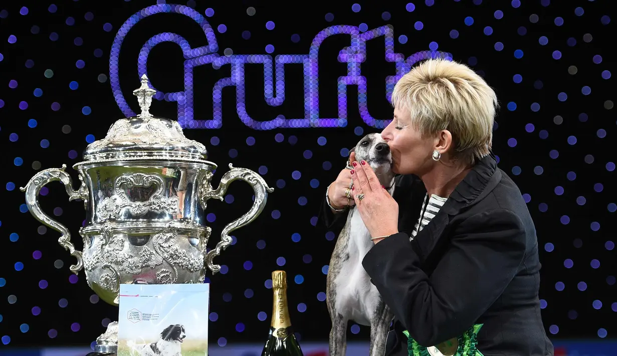 Yvette Short mencium anjing  the Whippet miliknya setelah dinobatkan sebagai pemenang Best in Show pada hari terakhir Crufts dog show 2018 di Birmingham, Inggris (11/3). Crufts adalah salah satu acara anjing terbesar di dunia. (AFP Photo/Oli Scarff)
