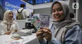 Warga menunjukkan uang rupiah baru usai melakukan penukaran di Hall Basket, Kompleks Gelora Bung Karno, Senayan, Jakarta, Jumat (21/3/2025). (Liputan6.com/Angga Yuniar)