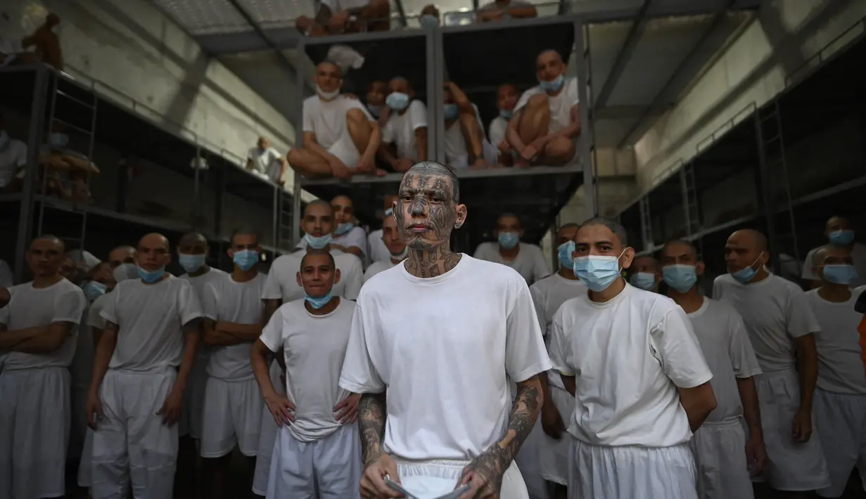 Di kompleks penjara di Tecoluca, sebelah tenggara ibu kota San Salvador, puluhan narapidana dengan kepala plontos mengintip dari satu blok sel. (Marvin RECINOS / AFP)