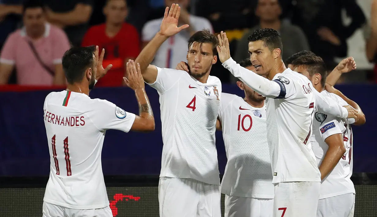 Para pemain Portugal merayakan gol yang dicetak Cristiano Ronaldo ke gawang Serbia pada laga Kualifikasi Piala Eropa 2020 di Belgrade, Sabtu (7/9). Serbia kalah 2-4 dari Portugal. (AFP/Pedja Milosavljevic)