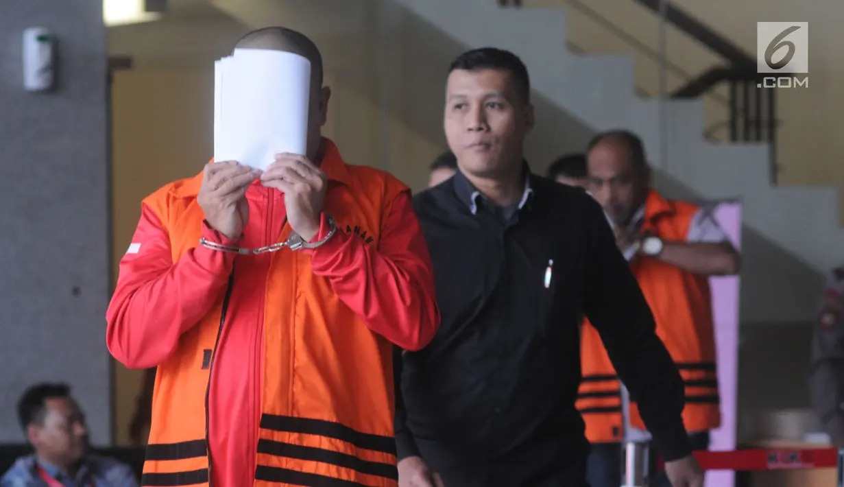 Pejabat Pembuat Komitmen pada Kemenpora Adhi Purnomo (kiri) menutupi wajahnya dengan kertas usai menjalani pemeriksaan oleh penyidik di Gedung KPK, Jakarta, Selasa (12/3). (merdeka.com/Dwi Narwoko)
