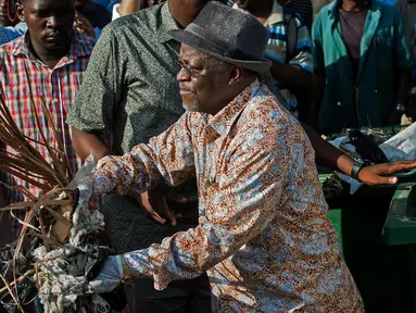 Presiden Tanzania, John Magufuli bergabung dengan warga untuk ikut ambil bagian dalam operasi pembersihan umum di kota utama Dar es Salaam, Rabu (9/12). Ini merupakan bagian dari acara untuk menggantikan perayaan hari kemerdekaan. (DANIEL HAYDUK/AFP)