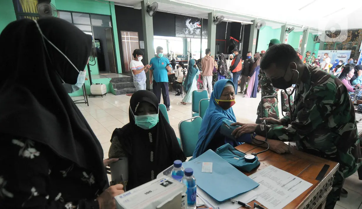 Warga menjalani pemeriksaan kesehatan saat distribusi Bantuan Tunai untuk Pedagang Kaki Lima dan Warung (BTPKLW) di Markas Kodim 0508/Depok, Jawa Barat, Rabu (20/10/2021). Bantuan diberikan dengan syarat di antaranya dokumen dari masing-masing Babinsa dan sudah divaksin. (merdeka.com/Arie Basuki)