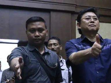 Advokat Lucas (kanan) mengacungkan jempol jelang sidang dakwaan di Pengadilan Tipikor, Jakarta, Rabu (7/11). Lucas didakwa menghalangi proses penyidikan KPK terhadap tersangka mantan petinggi Lippo Group, Eddy Sindoro. (Liputan6.com/Helmi Fithriansyah)