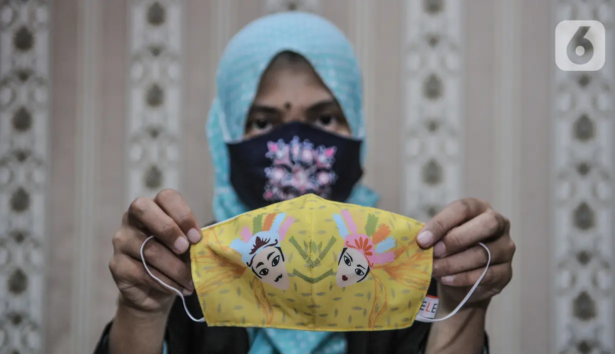 Pekerja menunjukkan masker bermotif batik Betawi yang selesai dibuat di Butik Elemwe, Jakarta, Selasa (22/12/2020). Elemwe memiliki rancangan khas dalam membuat masker dengan menggunakan batik Betawi. (merdeka.com/Iqbal S. Nugroho)