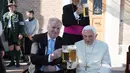 Paus Emeritus Benediktus XVI bersulang dengan dengan Perdana Menteri Bavaria Horst Seehofer saat merayakan ulang tahunnya yang ke-90 di Vatikan (17/4). (L'Osservatore Romano/Pool Photo via AP)