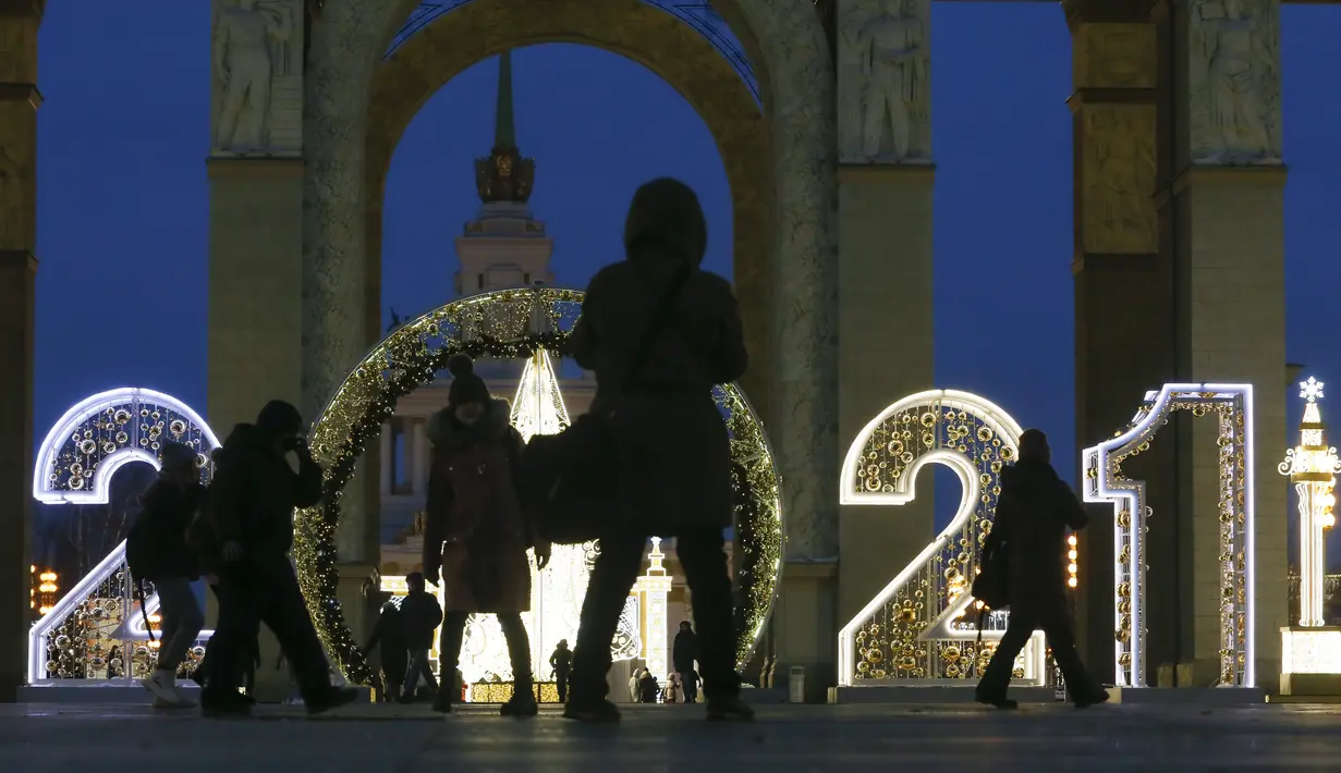 Orang-orang berjalan melintasi instalasi lampu yang dipasang untuk menyambut libur Tahun Baru dan Natal Ortodoks di Moskow, Rusia, pada 29 Desember 2020. (Xinhua/Alexander Zemlianichenko Jr)