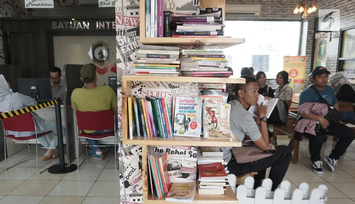 Warga menunggu pembuatan Surat Keterangan Catatan Kepolisian (SKCK) dengan membaca di perpustakaan mini di Mapolres Tangerang Selatan, Banten, Kamis (5/7). Selain memberi rasa nyaman, hal ini juga untuk meningkatkan minat baca. (Merdeka.com/Arie Basuki)