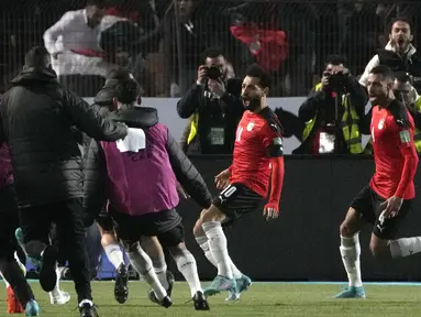 Pemain Mesir Mohamed Salah (tengah) bersama rekan satu timnya merayakan gol mereka ke gawang Senegal pada pertandingan kualifikasi Piala Dunia 2022 di Stadion Internasional Kairo, Kairo, Mesir, 25 Maret 2022. Mesir menang 1-0. (AP Photo/Amr Nabil)