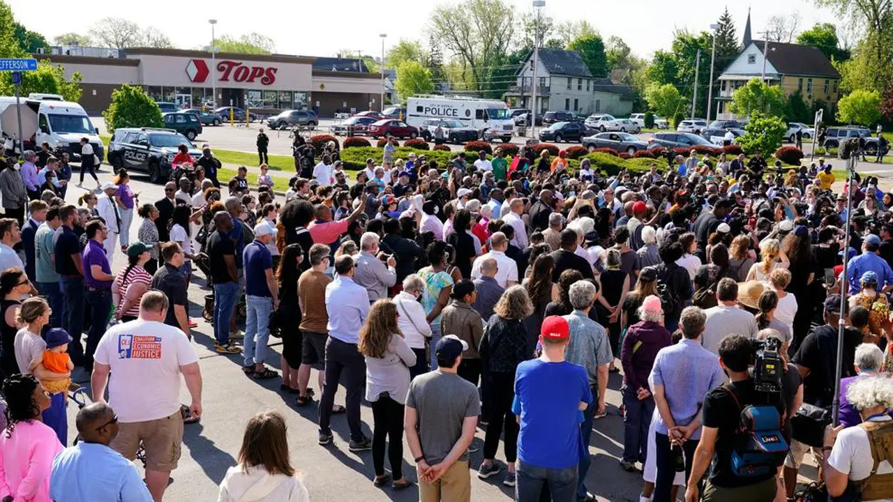 Kerumunan berkumpul saat polisi menyelidiki penembakan di supermarket Tops pada Sabtu, 14 Mei 2022, di Buffalo, NY. (Foto AP/Joshua Bessex)