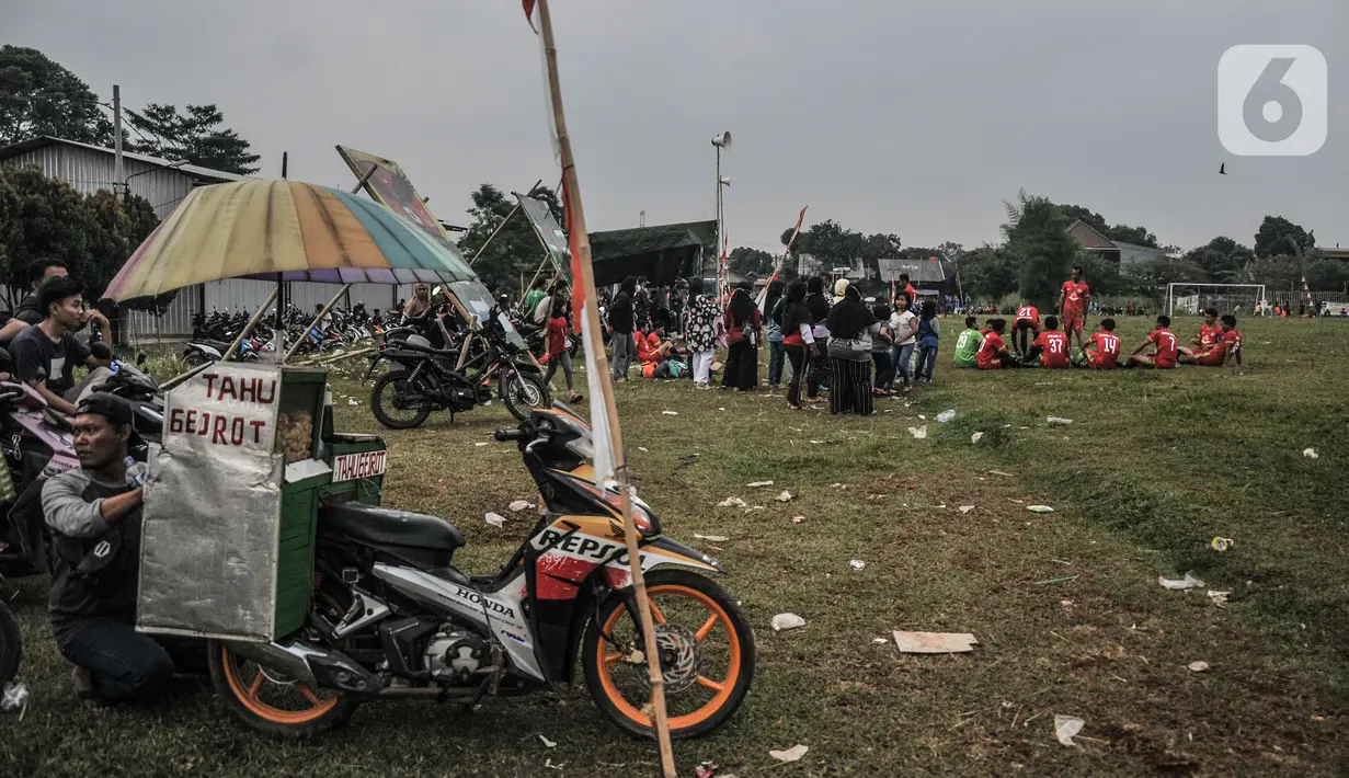 PKL berjualan selama turnamen sepak bola Tarkam di Desa Ragajaya, Bojong Gede, Kabupaten Bogor, Jawa Barat, Minggu (17/10/2021). Setelah sempat terhenti hampir 2 tahun, warga di Desa Ragajaya kembali menggelar turnamen sepak bola tahunan yang mereka sebut 'Liga Kocok'. (merdeka.com/Iqbal S. Nugroho)