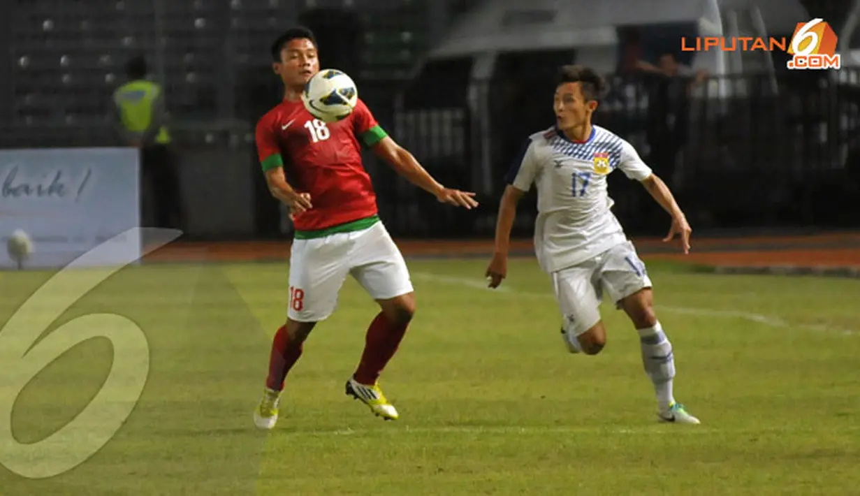 Pemain Indonesia, Dedi Kusnandar (bernomor 18) berusaha mempertahankan bola dari kejaran pemain Laos (Liputan6.com/Helmi Fithriansyah)