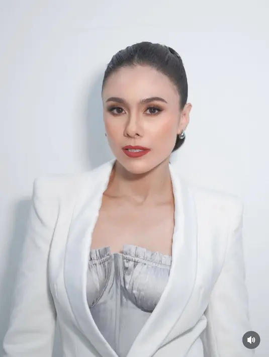 Wulan tampil dengan riasan blush on coral dan lipstik merah matte. Rambutnya diikat ponytail dengan hiasan gold. [@wulanguritno]