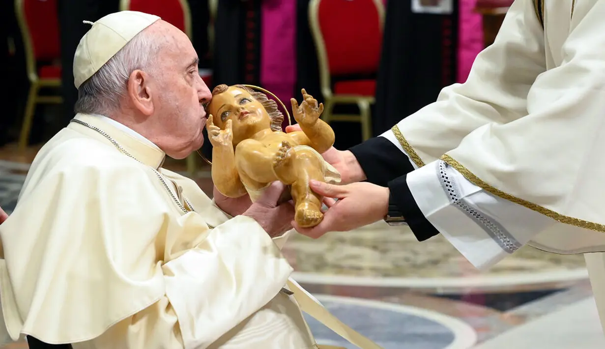 <p>Seorang anak perempuan melihat patung Bayi Yesus saat Paus Fransiskus memimpin Misa Malam Natal di Basilika Santo Petrus, Vatikan, 24 Desember 2022. Paus Fransiskus mengangkat tema keserakahan dalam pidatonya. (AP Photo/Gregorio Borgia)</p>