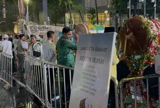 Hujan deras yang mengguyur Jakarta pada Jumat (20/3/2026) malam tidak menyurutkan antusias warga menikmati malam takbiran di Car Free Night Bundaran HI. (Liputan6.com/Delvira Hutabarat)