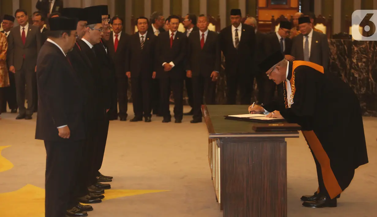 Ketua MA Hatta Ali menandatangani surat sumpah jabatan anggota Badan Pemeriksa Keuangan periode 2019-2024 di Gedung Mahkamah Agung, Kamis (17/10/2019). Kelima anggota BPK adalah Pius Lustrilanang, Daniel Lumban Tobing, Hendra Susanto, Ahsanul Qosasi dan Harry Azhar Azis. (Liputan6.com/Angga Yuniar)
