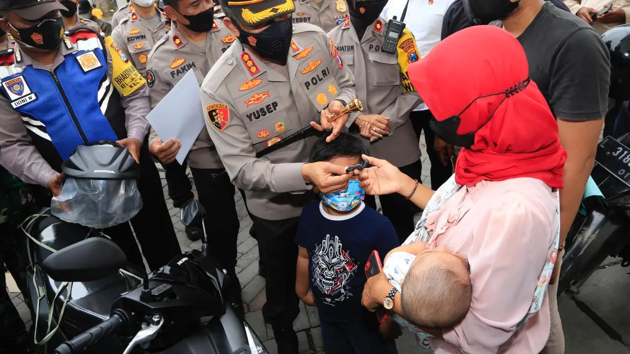 Kapolrestabes Surabaya Kombes Pol Akhmad Yusep Gunawan menyerahkan motor dari Jokowi untuk  Wahyu Novi Arini. (Dian Kurniawan/Liputan6.com)