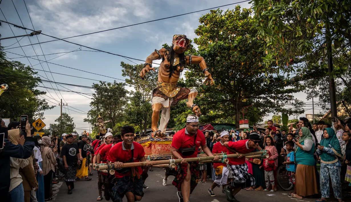 Umat Hindu membawa Ogoh-Ogoh selama pawai di kawasan Pura Segara sehari sebelum Hari Raya Nyepi di Surabaya pada 21 Maret 2023. (AFP/Juni Kriswanto)