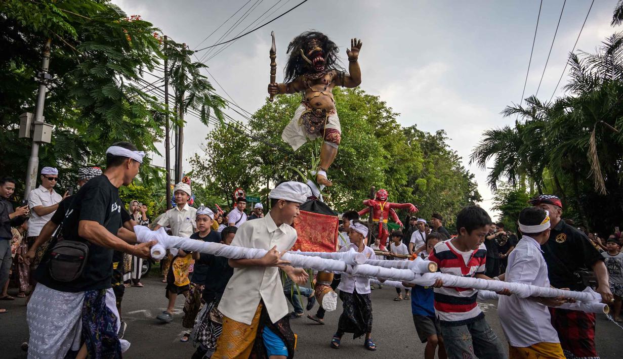 Umat Hindu membawa Ogoh-ogoh, patung yang melambangkan roh jahat, selama pawai menjelang Nyepi di Surabaya pada Rabu 18 Maret 2026. Menyambut datangnya Hari Raya Nyepi, umat Hindu di kota Surabaya, Jawa Timur, menggelar pawai Ogoh-ogoh. (JUNI KRISWANTO/AFP)