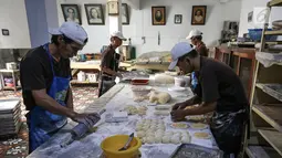 Sejumlah karyawan membuat bahan adonan roti di Toko Roti GO, Purwokerto, Jawa Tengah, Senin (22/4). Memasuki usia ke 121 tahun, toko roti yang berdiri sejak tahun 1898 ini dibuat mengunakan peralatan tradisional dan tanpa bahan pengawet. (Liputan6.com/Fery Pradolo)