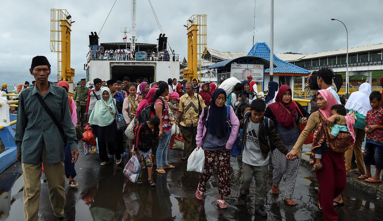 Para pengungsi turun dari kapal ferry usai dievakuasi dari Pulau Sebesi, di Pelabuhan Bakauheni, Lampung, Rabu (26/12). Ribuan pengungsi tsunami dari Pula Sebesi terpaksa dievakuasi menggunakan kapal ferry. (AFP Photo/Mohd Rasfan)
