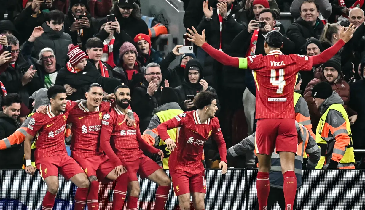 Pemain depan Liverpool, Mohamed Salah (tengah) merayakan golnya bersama dengan rekan setimnya saat laga matchday 7 League Phase Liga Champions 2024/2025 melawan Lille LOSC yang digelar di Stadion Anfield, Inggris, Selasa (21/1/2025) waktu setempat atau Rabu (22/1/2025) dini hari WIB. (Paul ELLIS/AFP)