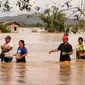 Warga mengarungi jalan raya yang banjir terjangan topan Phanfone di Ormoc City, Provinsi Leyte, Filipina, Rabu (25/12/2019). Topan membuat jutaan warga di negara yang mayoritas beragama Katolik itu merayakan Natal dengan kesedihan. (RONALD FRANK DEJON/AFP)