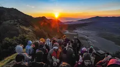 Pengunjung memadati Love Hill menunggu matari terbit di Bromo, Jawa Timur. Gunung Bromo dikenal sebagai salah satu lanskap paling magis di Indonesia. Perpaduan antara gunung megah, lautan pasir luas, serta kabut tipis yang menari di pagi hari menciptakan panorama emas yang sulit ditandingi. (merdeka.com/Arie Basuki)