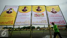 Seorang pekerja melintasi baliho Ade Komarudin di kawasan alun alun utara Yogyakarta, Jumat (11/3/2016). Ade Komarudin akan mendekalrasikan pencalonan ketua Umum DPP Golkar yang akan bertarung pada Munaslub 2016. (Liputan6.com/Boy Harjanto)