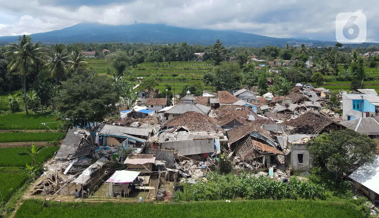 Foto udara memperlihatkan pemukiman yang hancur akibat gempa di Desa Sarampad, Kabupaten Cianjur, Jawa Barat, Selasa (22/11/2022). Warga yang terdampak gempa berharap bantuan seperti makanan, obat-obatan, selimut, dan petugas medis bisa segera datang. (Liputan6.com/Herman Zakharia)