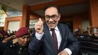 Mantan pemimpin oposisi Malaysia, Anwar Ibrahim mengacungkan ibu jari ke arah para jurnalis saat keluar dari RS Rehabilitasi Cheras, Kuala Lumpur, Rabu (16/5). Anwar Ibrahim bebas dari penjara setelah mendapat pengampunan. (AFP/MOHD RASFAN)