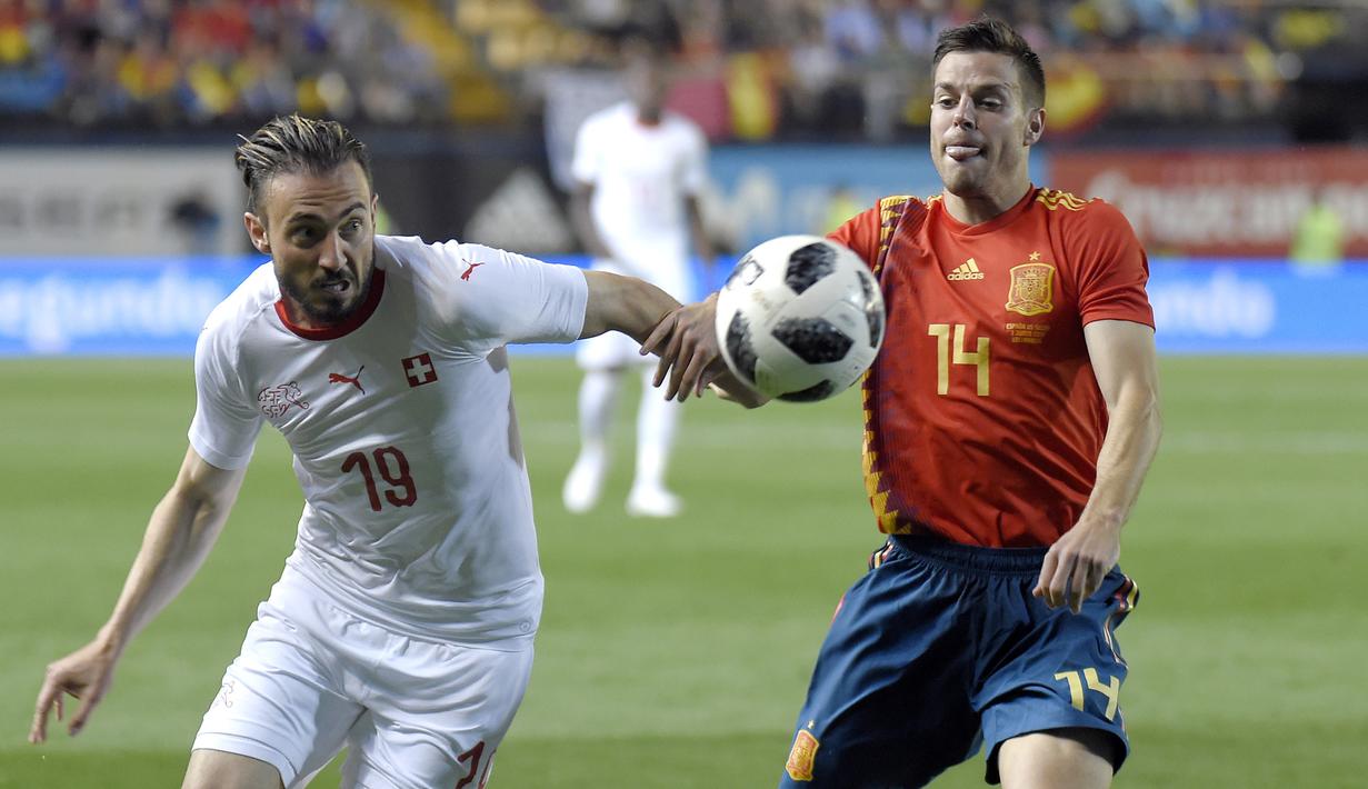 Bek Spanyol, Cesar Azpilicueta, berebut bola dengan striker Swiss, Josip Drmic, pada laga persahabatan di Stadion La Ceramica, Vila-real, Minggu (3/6/2018). Kedua negara bermain imbang 1-1. (AFP/Jose Jordan)