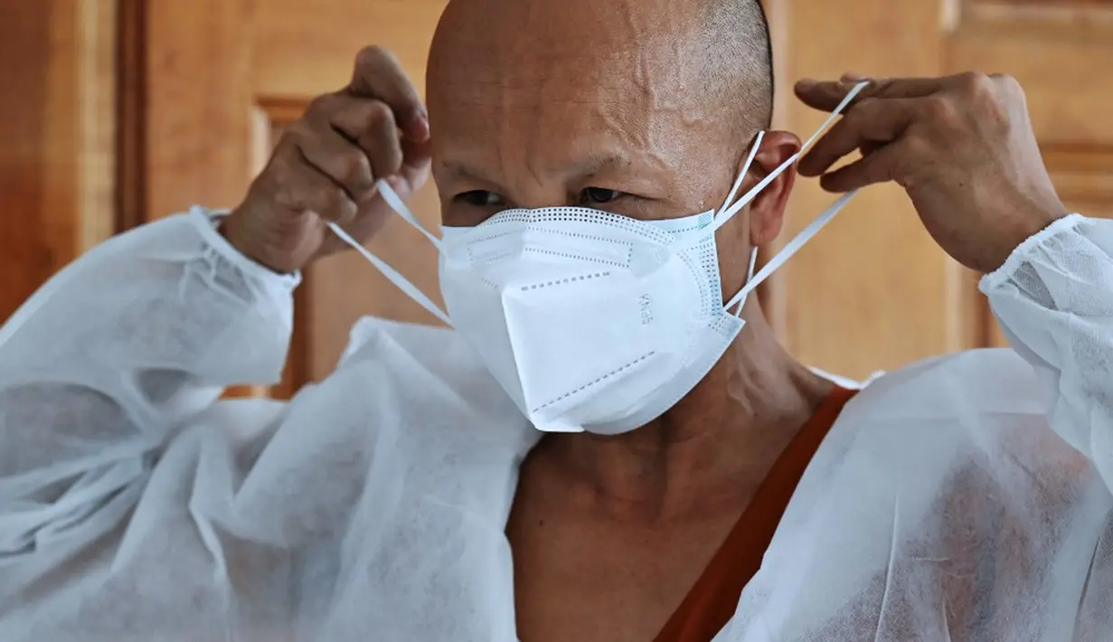 Seorang biksu mengenakan alat pelindung diri sebelum melakukan kremasi untuk korban virus corona COVID-19 di Wat Chin Wararam Worawihan, Bangkok, Thailand, 30 Juli 2021. Kasus COVID-19 di Thailand kini tengah melonjak. (Lillian SUWANRUMPHA/AFP)