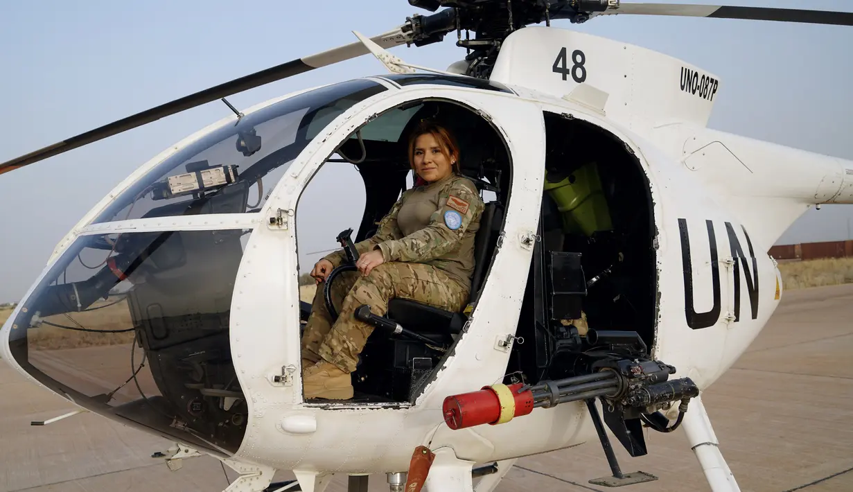Kapten Sandra Hernandez (36) berpose di samping helikopternya di pangkalan MINUSMA, Timbuktu, Mali,  Senin (19/2). (AFP PHOTO/Sebastien Rieussec)