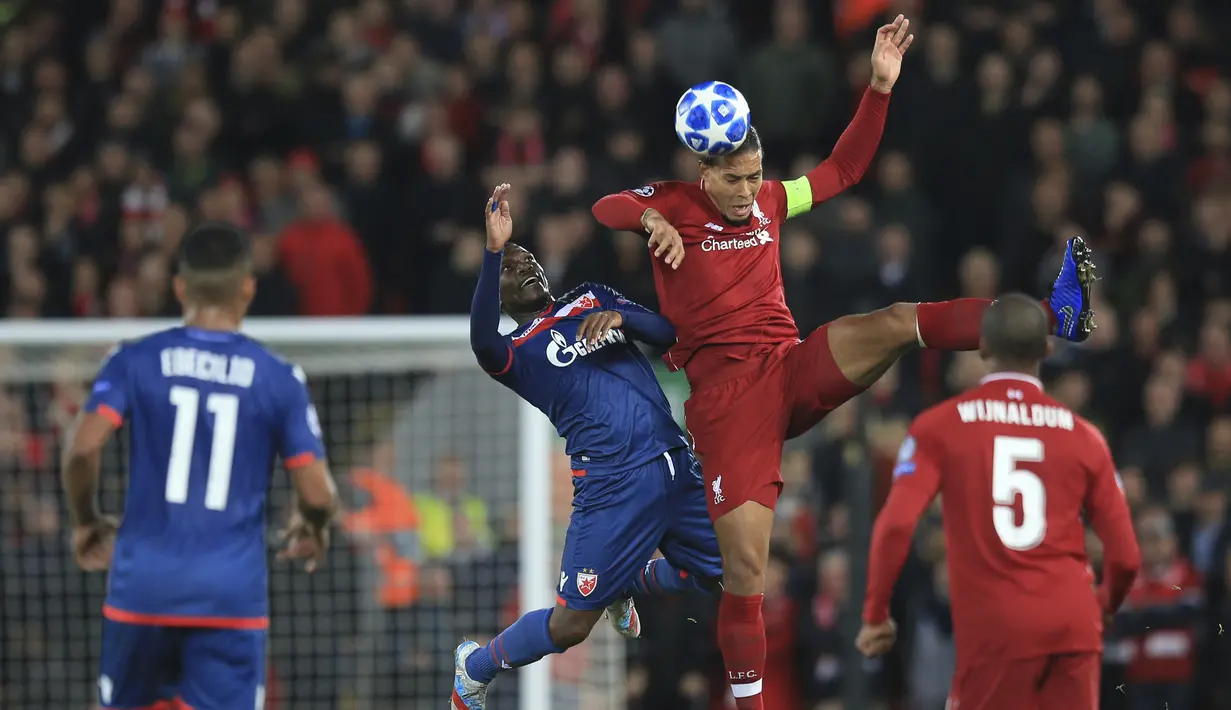Bek Liverpool, Virgil Van Dijk, duel udara dengan dengan pemain Crvena Zvezda, El Fardou Ben Nabouhane, pada laga Liga Champions, di Stadion Anfield, Rabu (24/10/2018). Liverpool menang 4-0 atas Crvena Zvezda. (AP/Jon Super)