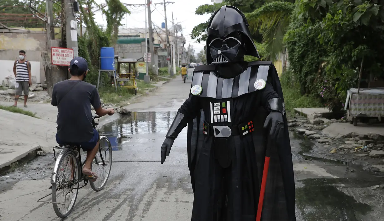 Anggota kelompok pemuda dalam kostum Star Wars menghibur warga di Malabon, Metro Manila, Filipina, Kamis (30/4/2020). Kelompok pemuda berkostum Star Wars menghibur warga selama karantina berkelanjutan akibat COVID-19 serta mengingatkan mereka agar tetap di rumah. (AP Photo/Aaron Favila)