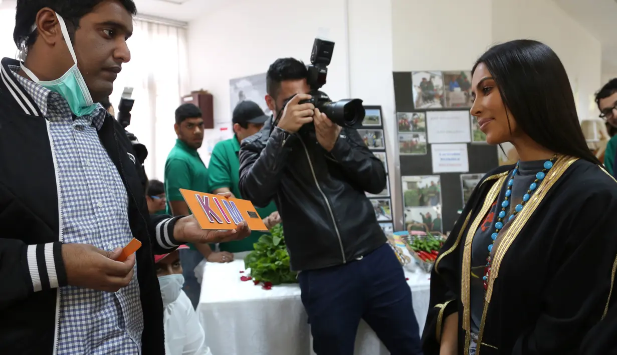 Kim Kardashian berbincang dengan anak penyandang cacat di Rashid Media Centre, Dubai (16/1). Kim Kardashian diberi kesempatan untuk belajar tentang kegiatan dan program yang diterapkan di Rashid Media Centre. (AFP Photo And Rashid Media Center/Stringer)