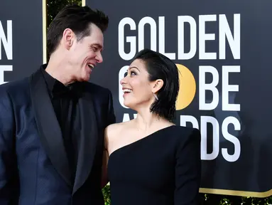 Komedian Jim Carrey dan Ginger Gonzaga bertatapan di karpet Golden Globe Awards ke-76 di Beverly Hills, California (6/1). Jim Carrey datang ke Golden Globes 2019 dengan menggandeng kekasih barunya, Ginger Gonzaga. (Frazer Harrison/Getty Images/AFP)