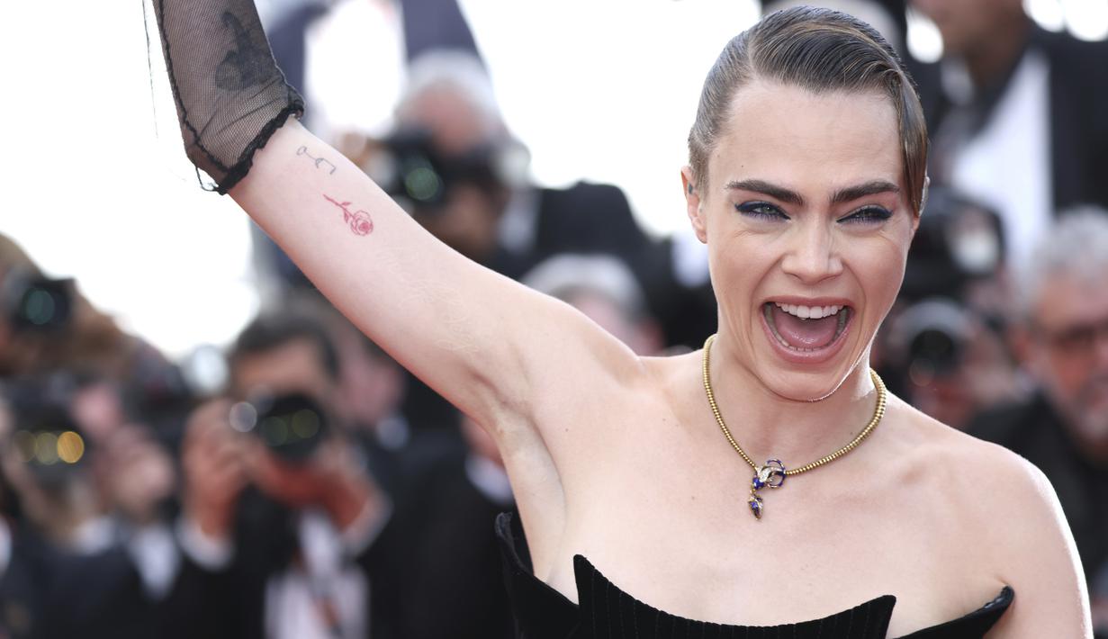 <p>Model Inggris Cara Delevingne berpose saat tiba menghadiri pemutaran film "The Innocent (L'Innocent)" selama Festival Film Cannes edisi ke-75 di Cannes, Prancis selatan (24/5/2022). Cara Delevingne menarik perhatian dalam gaun hitam yang pas dengan bentuk tubuh. (AP Photo/Vianney Le Caer)</p>