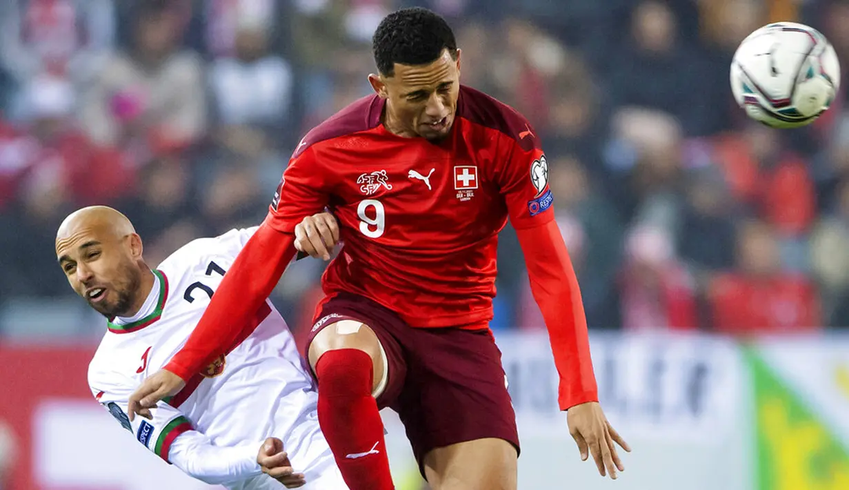 Pemain Bulgaria Momchil Tsvetanov (kiri) dan pemain Swiss Noah Okafor memperebutkan bola pada pertandingan sepak bola kualifikasi Piala Dunia 2022 di Stadion Swissporarena, Lucerne, Swiss, 15 November 2021. Swiss menang 4-0. (Urs Flueeler/Keystone via AP)
