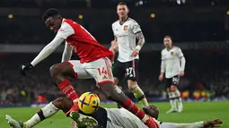 Pemain Arsenal, Eddie Nketiah berusaha melewati pemain Manchester United, Aaron Wan Bissaka pada laga lanjutan Liga Inggris 2022/2023 yang berlangsung di Emirates Satdium, London, Minggu (23/01/2023).