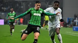 Pemain Sassuolo, Jay Idzes (kanan) berebut bola dengan pemain Inter Milan, Ange-Yoan Bonny dalam laga lanjutan Liga Italia 2025/2026 di Mapei Stadium, Minggu (08/02/2026) waktu setempat. (AFP/Piero Cruciatti)