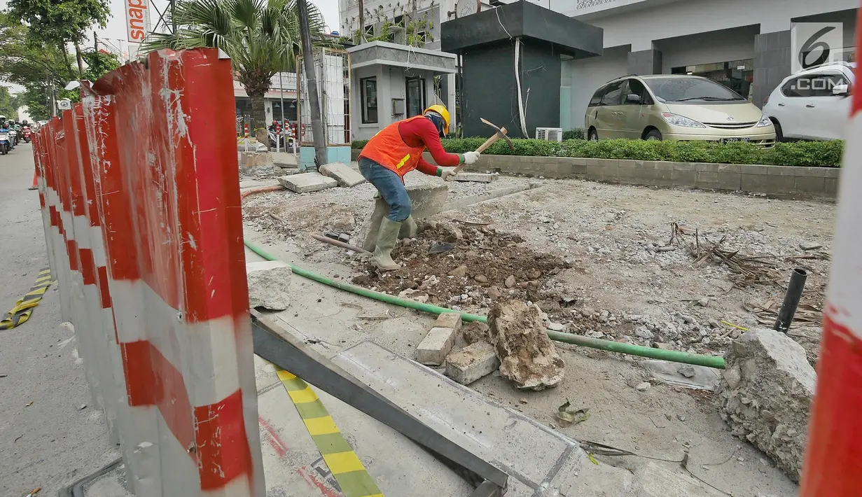 Pekerja menyelesaikan proyek revitalisasi trotoar di kawasan Kemang, Jakarta, Jumat (29/6/2019). Revitalisasi trotoar Kemang ditargetkan selesai pada November 2019. (Liputan6.com/Herman Zakharia)