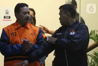 Wali Kota Madiun, Maidi (kiri) dijaga petugas sesaat sebelum menuju mobil tahanan usai pemeriksaan intensif di Gedung Merah Putih Komisi Pemberantasan Korupsi (KPK0, Jakarta, Selasa (20/1/2026). Bersama dua orang lainnya, yakni Rochim Ruhdiyanto selaku orang kepercayaan Maidi dan Thariq Megah selaku Kepala Dinas PUPR Kota Madiun, Komisi Pemberantasan Korupsi (KPK) menetapkan Wali Kota Madiun, Maidi sebagai tersangka sekaligus melakukan penahanan. (Liputan6.com/Helmi Fithriansyah)