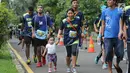 Pelari membawa anaknya saat mengikuti lomba Pertamina Eco Run 2017 di Pantai Karnaval Ancol, Jakarta, Sabtu (16/12). Pertamina Eco Run 2017 diikuti ribuan pelari dari tiga kategori, yakni master, umum dan pelajar. (Liputan6.com/Helmi Fithriansyah)