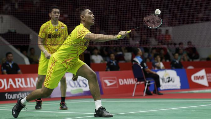 Ganda putra Indonesia, Fajar Alfian, berusaha memukul kok saat melawan rekan senegaranya pada Indonesia Masters 2019 di Istora Senayan, Jakarta, Rabu (23/1). Fajar / Rian gagal lolos ke semifinal. (Bola.com/Yoppy Renato)